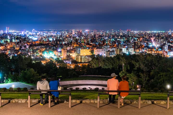 【北海道】札幌・旭山記念公園から夜景を眺めるデート中のカップルの写真